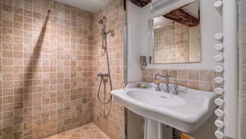 Un baño con ducha, lavamanos y espejo.