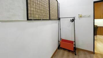 A room with a wooden floor, a window with a grid pattern, a door, and a red storage unit.