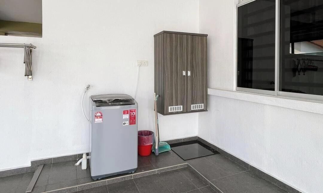 A room with a grey refrigerator, a cabinet, a window, and a tiled floor.