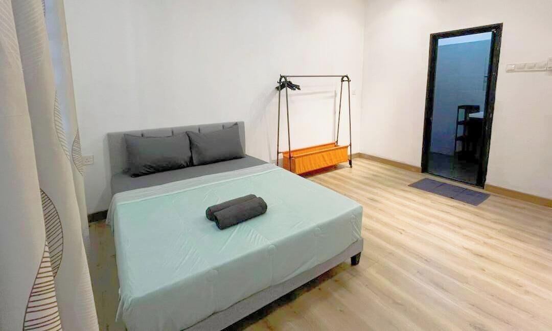 A bedroom with a bed, a swing, and a door.