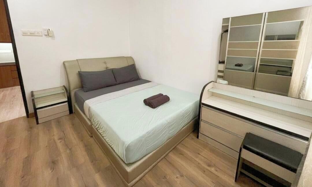 A bedroom with a bed, bedside tables, a dresser, and a mirror.