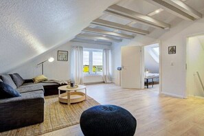 A modern loft apartment with an open-plan living area, a dining space, and a bedroom. - Holiday apartment with 1 bedroom (Westerdeichstrich)