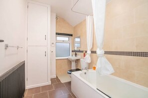 A bathroom with a bathtub, a sink, and a toilet. - 2-Bed Terrace Sleeps 6 · Garden & Free Parking · Near Warley Woods (West Midlands)