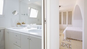 Un baño de hotel con dos lavamanos, un espejo grande y un mueble con cajones.