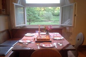 Mesa para dos con vista a un jardín a través de una ventana.