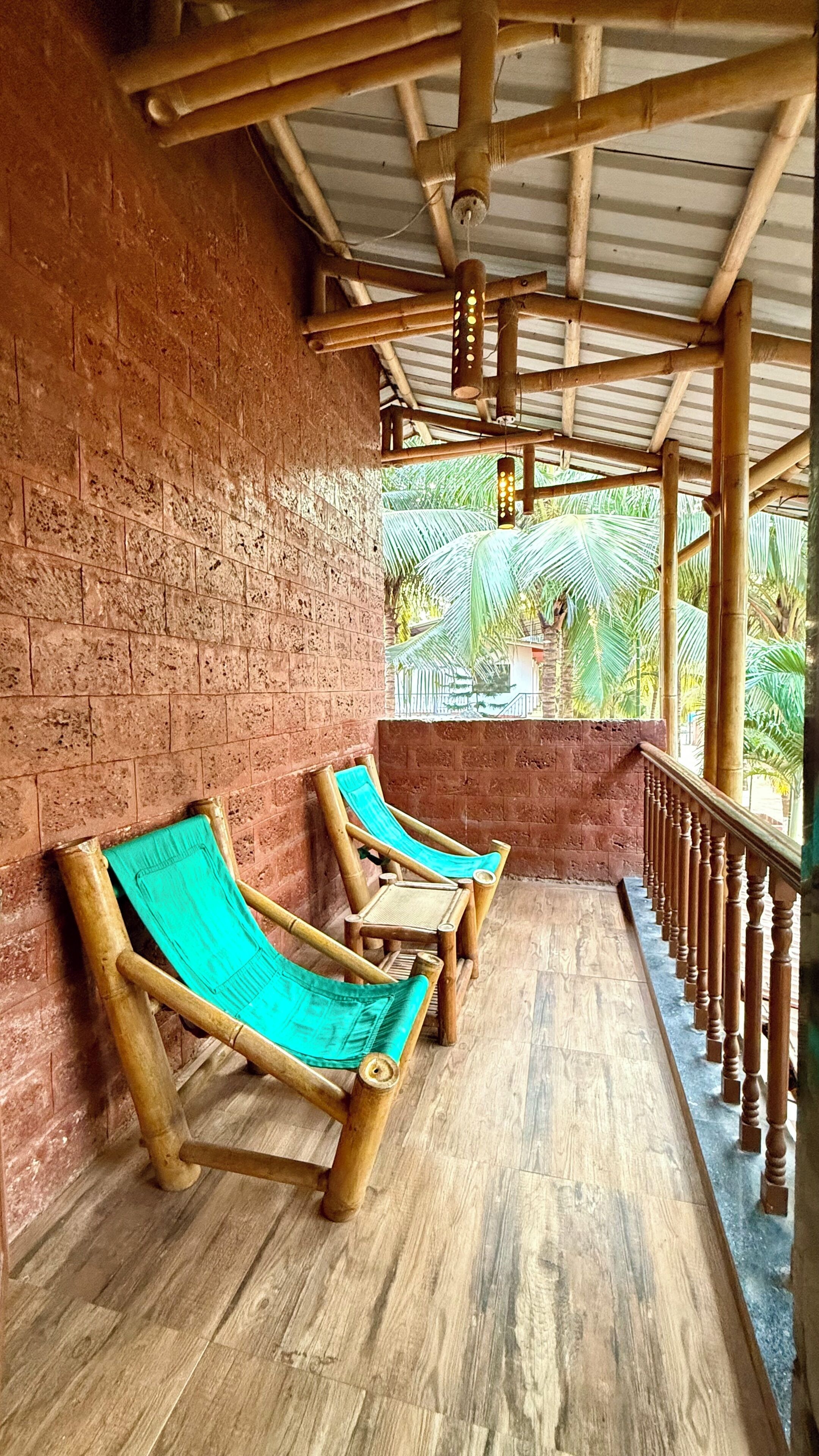 A covered outdoor seating area with wooden benches and a brick wall.