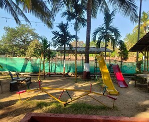A playground with swings, slides, and a fenced area.