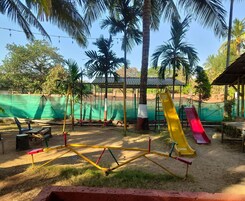 Un parque infantil con columpios, toboganes y una zona vallada.