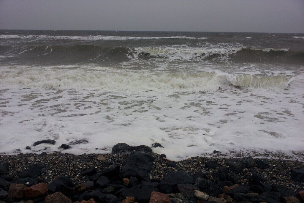 Een rotsachtig strand met golven die op de kust breken.