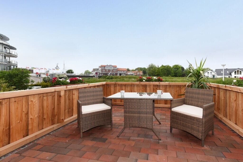 Une terrasse extérieure avec des meubles en osier et un sol en briques.
