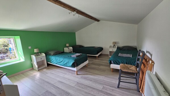 A room with two beds, a chair, and a window. - Vrbo Property (Coulon)