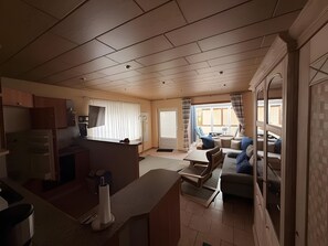A spacious living area with a kitchen, a dining table, and a sofa.