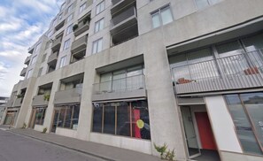 Un edificio de varios pisos con balcones, ventanas amplias y escaparates.