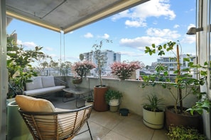 A balcony with a sofa, chairs, and potted plants. - Sunlit 2BD Apartment with Parking, Brunswick (Brunswick)