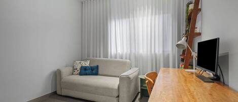 Ein modernes Wohnzimmer mit einer Couch, einem Holztisch und einem Fernseher.