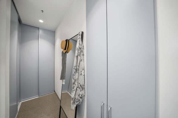 A hallway with a wardrobe, a hat, and a patterned cloth hanging on the wall. - Sunlit 2BD Apartment with Parking, Brunswick (Brunswick)
