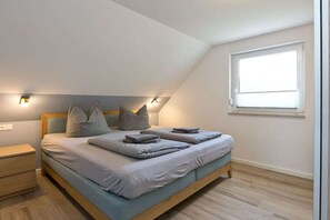 A bedroom with a bed, bedside tables, a window, and wall-mounted lights. - Holiday apartment with 2 bedrooms (Röbel\/Müritz)