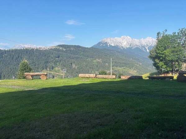 Un campo cubierto de hierba con una cadena montañosa al fondo.
