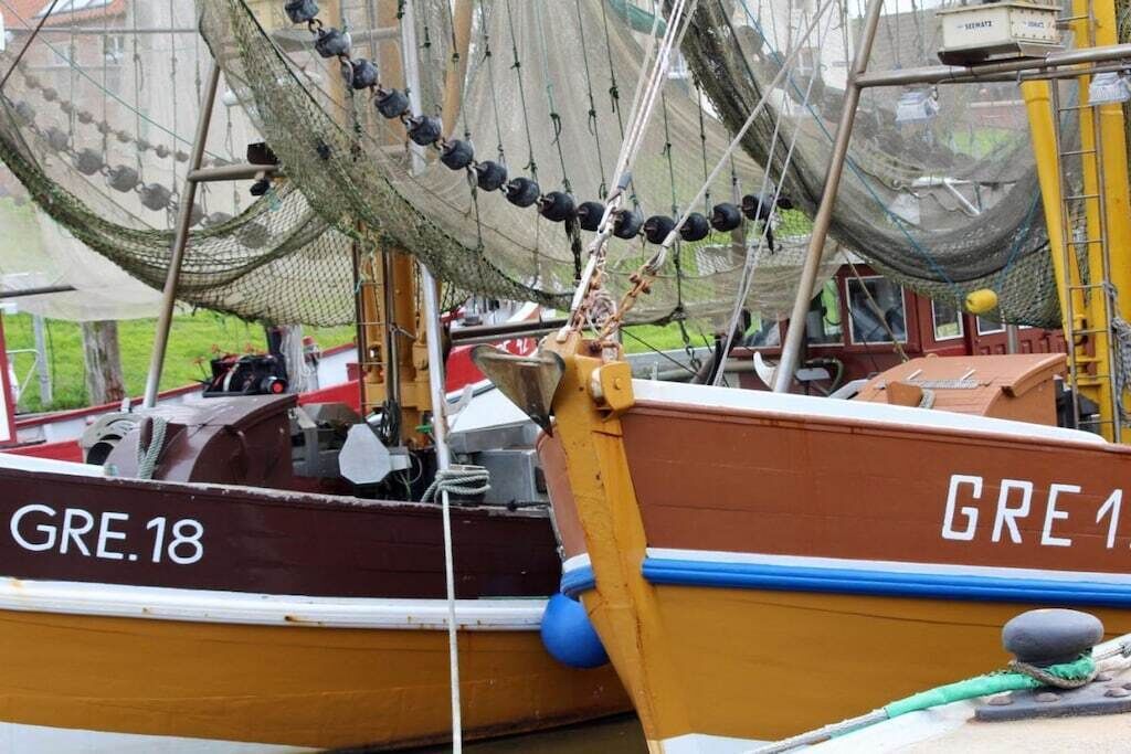 Ein Boot namens GRE.18 liegt mit Netz und Ausrüstung an.