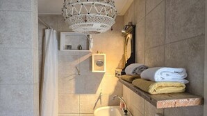 Un bagno con lavandino, specchio, porta asciugamani e tenda doccia.