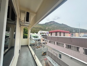 A balcony with a view of a mountain and buildings. - Azhagar Residency (Tiruvannamalai)