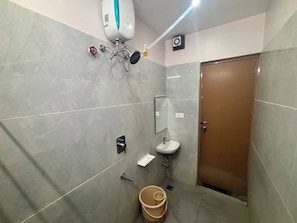 Et badeværelse med toilet, håndvask og bruser.