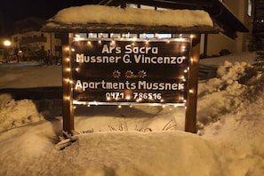 A sign for 'Ars Sacra Mussner G. Vincenzo Apartments Mussnek' with a phone number.