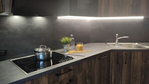 Una cocina moderna con estufa integrada, un lavabo y armarios de madera.