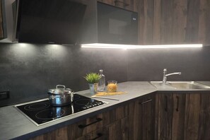 A modern kitchen with a built-in stove, a sink, and wooden cabinets.