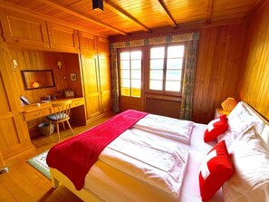 Quarto de cabana de madeira com uma cama, uma escrivaninha e uma cadeira.
