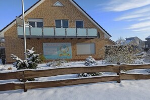 A two-story building with a signboard advertising a golf club. - Holiday apartment with 1 bedroom (Wiesmoor)