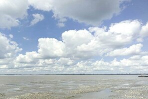 A wide view of a beach with a clear sky and a distant shoreline. - Holiday home with 2 bedrooms (Varel - Dangast)
