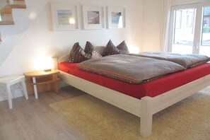 Une chambre à coucher avec un lit, une table de chevet et une fenêtre.
