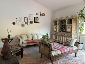 A living room with a sofa, armchairs, a coffee table, and a cabinet with decorative items. - Country house near the city, peace and quiet, nature, a pool, and a large garden. (Bucelas)