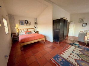 A bedroom with a bed, a wardrobe, a nightstand, a lamp, and a rug. - Country house near the city, peace and quiet, nature, a pool, and a spacious garden. (Bucelas)