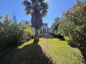 A house with a paved pathway leading to a set of stairs. - Country house near the city, peace and quiet, nature, a pool, and a large garden. (Bucelas)