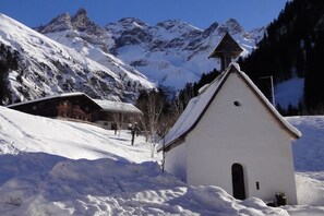 A snow-covered mountain landscape with a small white building and a wooden cabin. - Holiday apartment with 1 bedroom (Sonthofen)