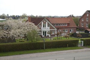 A residential building with a symmetrical facade, a central entrance with a white door, and a small balcony. - Holiday apartment with 1 bedroom (Grünendeich)