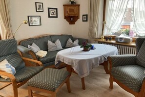 A cozy living room with a sofa, two armchairs, a round table, and a radiator. - Holiday apartment with 2 bedrooms (Lenzkirch)