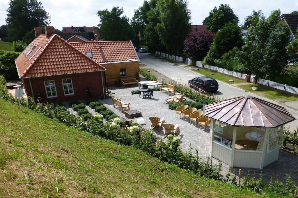 Ein Wohngebiet mit einem Haus, Sitzgelegenheiten im Freien und einem Pavillon.