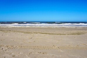 A beach with visible footprints and waves in the ocean. - Holiday home with 2 bedrooms (Julianadorp)