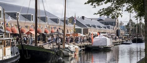 Un puerto deportivo con barcos amarrados, una multitud de gente y edificios con techos inclinados.