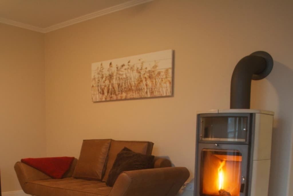 A living room with a sofa, a fireplace, and a painting on the wall.