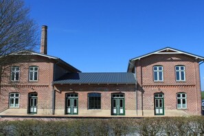 A two-story brick building with symmetrical windows and doors, a central chimney, and a flat roof. - Old Dairy Twedt - Boiler Room (Twedt)