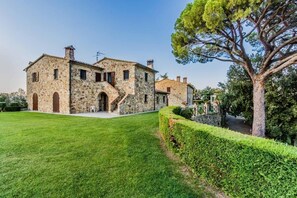 A stone building with a central staircase, a well-maintained lawn, and a large tree. - Agriturismo Aia Leccioni (Pomarance)