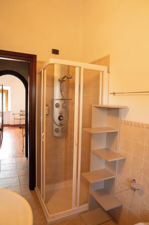 A walk-in shower with a control panel, a glass door, and a tiled floor. - Agriturismo Aia Leccioni (Pomarance)