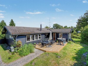 A two-story house with a patio area, outdoor seating, and a hot tub. - "Leve" - 300m from the sea by Interhome (Gedser)
