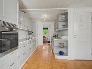 A kitchen with white cabinetry, a built-in oven, and a wooden floor. - "Leve" - 300m from the sea by Interhome (Gedser)