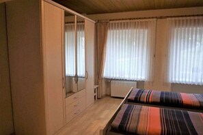 A bedroom with a bed, a wardrobe, and a radiator. - Holiday apartment with 1 bedroom (Enkirch)