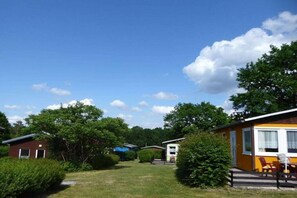 A row of mobile homes with a grassy yard and trees. - in the holiday village "Boeker Mühle" (Boeker Mühle)